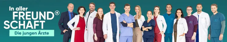 „In aller Freundschaft – Die jungen Ärzte“. Eine Gruppe von Ärzten und Ärztinnen in bunten Kitteln vor grünem Hintergrund.