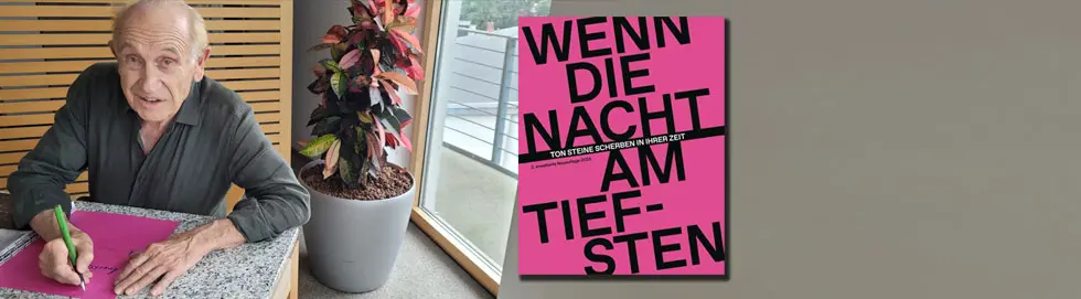 "Wenn die Nacht am tiefsten" steht auf einem pinken Buchcover; links sitzt ein Mann, der das Buchcover signiert.