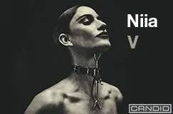 Text: "Niia V". Eine Frau mit aufwändigem Halsband. Unten rechts ist ein Logo.