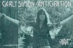 "Carly Simon / Anticipation" und "Mofi". Frau mit langen Ärmeln posiert draußen, umgeben von Bäumen.