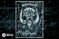 Text: "Motörhead" und "kiss of death". Graues, metallisches Totenkopf-Logo mit Waffen und Ketten auf Backstein-Hintergrund.