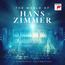 „THE WORLD OF HANS ZIMMER“, darunter „A SYMPHONIC CELEBRATION“. Eine Bühne mit einem Orchester in blauem Licht.