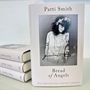 Auf dem Buchcover steht: "Patti Smith, Bread of Angels, Die Geschichte meines Lebens". Schwarz-weiß Foto einer Frau mit Blumenkranz., Buch
