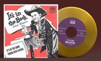 "Es steht im Buch. John Waters. Stolzer neuer Vater." Illustration eines Mannes im Anzug mit einem Buch und einem goldenen Vinyl., LP