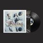 Text: Pixies, Trompe le Monde. Schwarze Vinyl-Schallplatte mit auffälligem Coverdesign aus Augen auf heller Oberfläche., LP