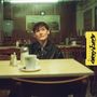 Text: „decembers“. Eine Person sitzt nachdenklich in einem leeren Café. Der Stil ist retro und gemütlich., CD