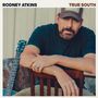 "RODNEY ATKINS" oben links, "TRUE SOUTH" oben rechts. Ein Mann mit Bart sitzt auf einem Stuhl vor einer Gitarre.