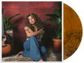 Eine Frau mit lockigem Haar sitzt umgeben von Pflanzen und einer Gitarre. Daneben eine goldene Schallplatte., LP