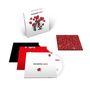 Auf den Objekten steht: "Dance for Joy When it's Mourning." Sichtbar sind rote Blumen auf weißem Hintergrund., 3 CDs