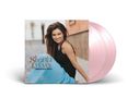 "Shania Twain Greatest Hits" steht auf einem Albumcover. Frau in schwarzem Top, lachend, sitzt draußen. Pinker Vinyl-Schallplattenhintergrund.