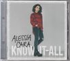 "Alessia Cara" und "Know-It-All" Text in großen Buchstaben. Junge Frau in Hemd und Jeans steht lässig vor grauem Hintergrund.