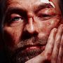 Ein Mann mit blauen Augen, Blutspuren im Gesicht, eine Wunde mit Pflaster an der Stirn, schaut ernst, Hand am Kinn., LP