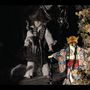 Eine Figur mit Fuchsmaske in einem bunten Kimono, daneben ein Puppenwesen mit Strohhut in dunkler Umgebung., 1 CD und 1 DVD