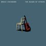 Text: "BRUCE COCKBURN THE BLOOD OF OTHERS". Illustration: Eine Gitarre lehnt an einem Stuhl auf blauem Hintergrund., 2 LPs
