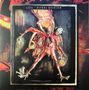 Text: "COIL · ASTRAL DISASTER". 

Eine abstrakte Figur mit mehreren Armen und maskenartigem Gesicht vor feurigem Hintergrund.