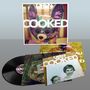 "OREN AMBARCHI COOKED DC994" steht auf einem Albumcover mit einem bunten Tier wie ein Plüschtier im Hintergrund.
