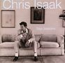 Text: "Chris Isaak," "Baja Sessions." Ein Mann in Anzug sitzt nachdenklich auf einem Sofa, gerahmte Bilder im Hintergrund.