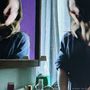 Text: "dream fatigue". Eine Person spiegelt sich in einem Badezimmer, umgeben von Flaschen und Kosmetikprodukten., CD