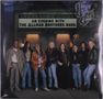 "An Evening with The Allman Brothers Band" auf einem Theaterbanner. Neun lächelnde Personen posieren entspannt davor., 2 LPs