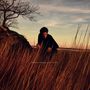 Text: "SIMON MOULLIER CEIBA". Eine Person in einem Feld mit hohem, braunem Gras, ein kahler Baum, Abendhimmel im Hintergrund., LP