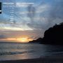 "Sven Kacirek, Songs from Okinawa." Sonnenuntergang am Meer mit Wolken und silhouettierten Hügeln im Hintergrund., LP