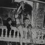 Keine sichtbaren Texte. Drei Menschen tanzen und lachen auf einem Balkon, umgeben von Konfetti. Retro-Stil, ausgelassene Stimmung., LP
