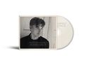 Texte: "Morten Harket", "Human Grace". Schwarz-weißes Porträt eines nachdenklichen Mannes vor einer Holzwand., CD