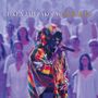 TIKEN JAH FAKOLY CHORALES. Ein Mann im bunten Gewand singt in ein Mikrofon, Menschen in weißer Kleidung im Hintergrund.