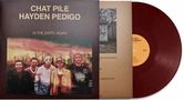 Text: "Chat Pile Hayden Pedigo In the Earth Again." Rotes Vinyl mit Cover, das fünf Personen vor einem surrealen Hintergrund zeigt.