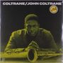 Text: "COLTRANE/JOHN COLTRANE". Eine ernst blickende Person lehnt sich über ein Saxophon. Gelb getöntes Cover.
