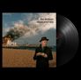 "Joe Jackson Hope and Fury." Eine Person im Mantel und Hut trinkt Tee, im Hintergrund brennt ein Pier., LP