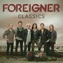 "FOREIGNER CLASSICS" steht oben. Sechs Männer stehen nebeneinander. Im Vordergrund liegt ein Gitarrenkoffer., MC