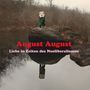 "August August: Liebe in Zeiten des Neoliberalismus." Eine verkleidete Figur mit Maske steht auf einem großen Felsen am Wasser., LP
