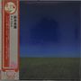 Japanische Schriftzeichen links auf orangem Band, darunter „1,800“. Dunkler Himmel über grünem Feld.