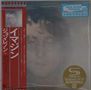 "New Music Fridays" Text oben rechts; Gesicht eines Mannes schwach im Hintergrund; rotes Banner mit japanischem Text links., CD
