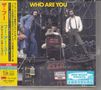 "WHO ARE YOU" in gelb oben, "NOT TO BE TAKEN AWAY" auf einem Stuhl. Drei Männer posieren inmitten von Kabeln., 2 CDs