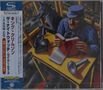 Links Text in japanischen Schriftzeichen, darunter "King Crimson", "The Night Watch Live 1973". Rechts ein Mann mit Buch., 2 CDs