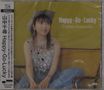 „Happy-Go-Lucky, Chihiro Yamanaka“. Frau mit kariertem Hut, sitzend auf einem Sofa vor gelbem Hintergrund., CD