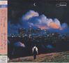 Text in japanischer Schrift. Stadtansicht mit beleuchteter Skyline, Person von hinten gehend, über Felder, Nachtstimmung., CD