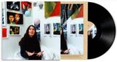 Ein schwarzes Vinyl neben einem Albumcover. Eine Frau sitzt vor bunten Gemälden und jongliert mit Bällen., LP