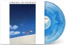 Text: "CHRIS REA · ON THE BEACH". Eine bunte Strandliege auf Sand vor blauem Himmel. Schallplatte in Blau., LP