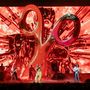 Eine dynamische Bühnenszene mit riesiger skulpturaler Schere und futuristischem Hintergrund in Rot., 2 CDs