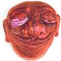Eine skulpturartige, rote Figur mit geschlossenen Augen und freundlichem Lächeln., LP