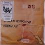 Texte: "AS SAFE AS YESTERDAY IS", "HUMBLE PIE", "FRAGILE WITH CARE". Design: Paket mit Siegel und Kordel.