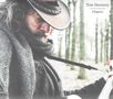 Text: "Tom Moriarty Chapters". Ein Mann mit Cowboyhut spielt Gitarre in einem Wald. Er trägt einen Schal., CD