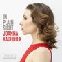 IN PLAIN SIGHT JOANNA KACPEREK. Eine Frau im Profil mit lockigem Haar und roten Kleid. Darunter Rubicon-Logo., CD
