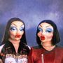 Zwei Figuren mit auffälligem Make-up und puppenartigen Gesichtern, tragen bunte Kleidung., LP