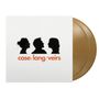 case/lang/veirs in orange, drei schwarze Silhouetten von Gesichtern im Profil darüber. Golden schimmernde Schallplatten., 2 LPs