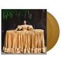 Eine Person in einem goldenen, ausladenden Kleid steht vor einer dunklen Wand. Daneben eine goldene Schallplatte., 2 LPs