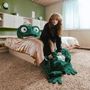 Kein Text sichtbar. 
Eine Person in einem Zimmer mit einem riesigen grünen Frosch-Plüsch auf dem Bett. Gemütliche Atmosphäre., CD